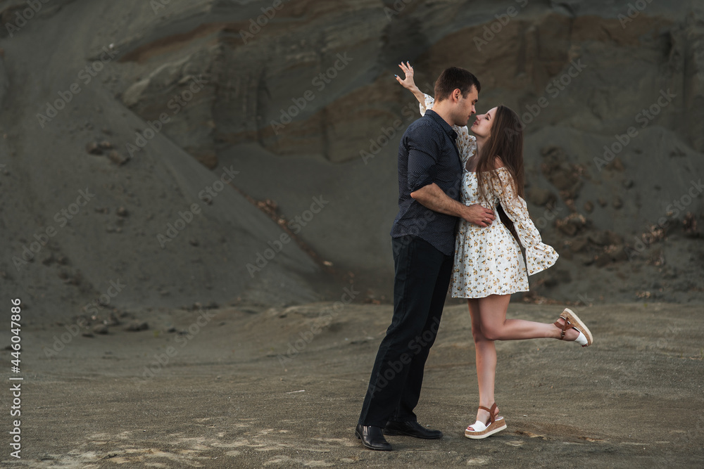 Happy couple dancing outdoors at summertime on gray sand background Happy couple dancing outdoors at summertime on gray sand background