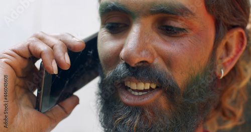 Closeup shot of a smiling Sout Asian male with a beard speaking on phone photo