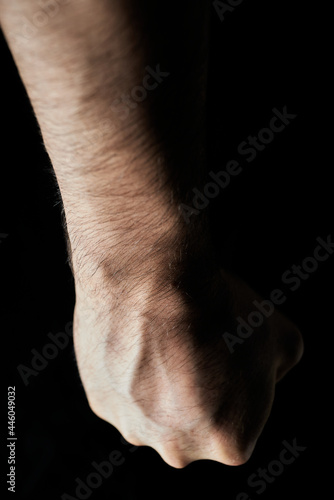man s fist on black background