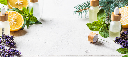 Different types of essential oils in glass bottles and ingredients for making essential oils. Skin and body care concept.