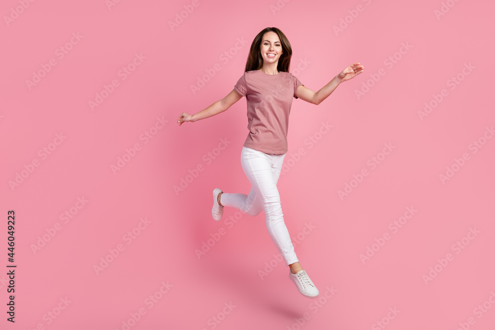 Full length body size view of attractive cheerful girl jumping good mood walking isolated over pink pastel color background Full length body size view of attractive cheerful girl jumping good mood walking isolated over pink pastel color background