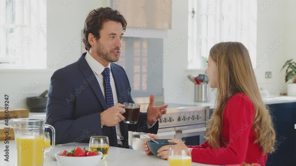 Father Wearing Suit Having Breakfast With Teenage Daughter In School Uniform At Home In Kitchen Father Wearing Suit Having Breakfast With Teenage Daughter In School Uniform At Home In Kitchen