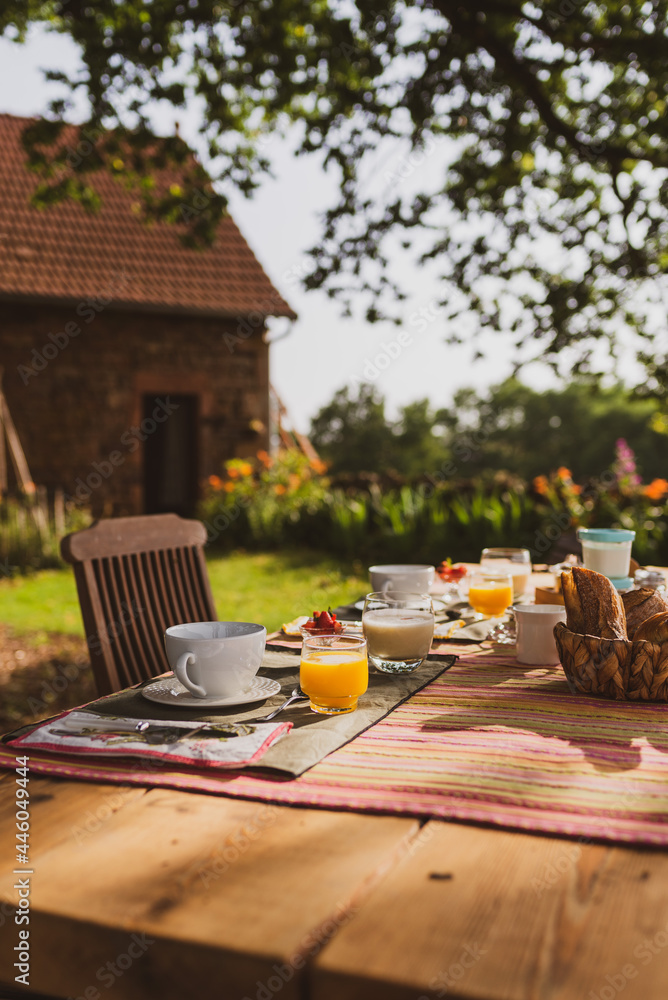 Orange juice breakfast with croissants in a French garden