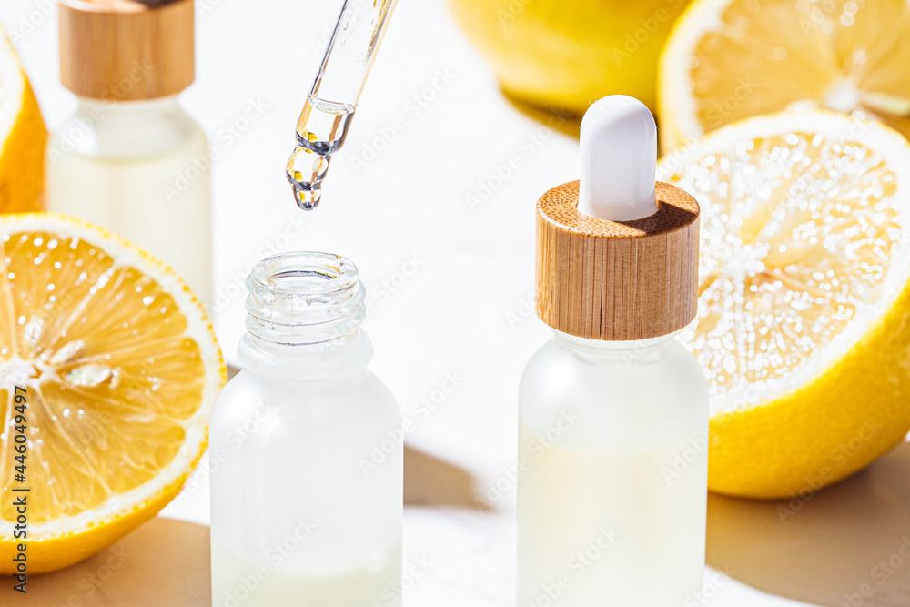 Lemon essential oil in glass bottles, white marble background. Skin and body care concept. Lemon essential oil in glass bottles, white marble background. Skin and body care concept.