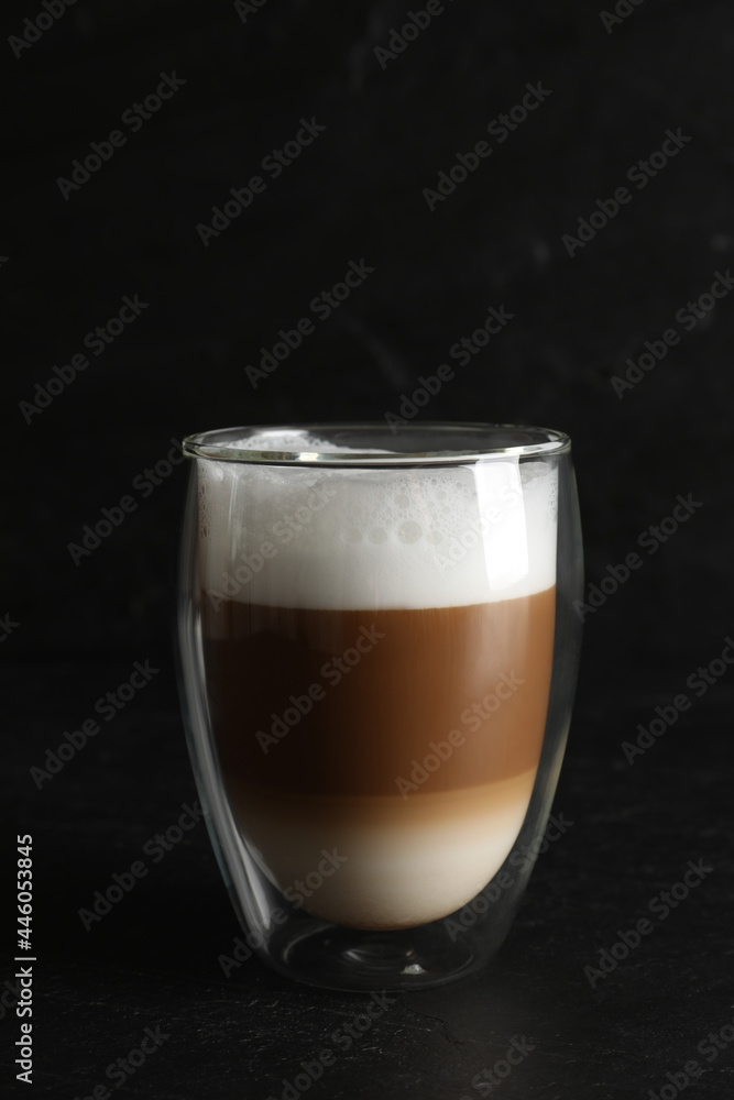 Hot coffee with milk in glass on black table Hot coffee with milk in glass on black table