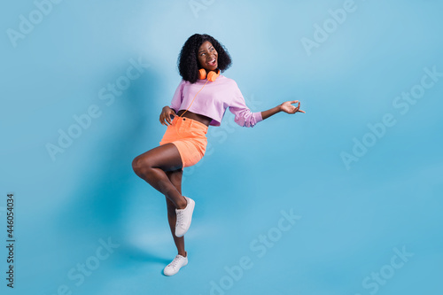Full length body size view of attractive cheerful wavy-haired girl having fun dancing fooling isolated on bright blue color background