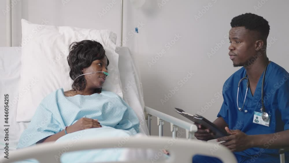 A young African-American male doctor is talking to a patient. A black woman patient talks to a doctor A young African-American male doctor is talking to a patient. A black woman patient talks to a doctor