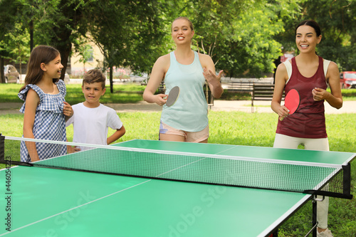 Happy family with children playing ping pong in park © New Africa