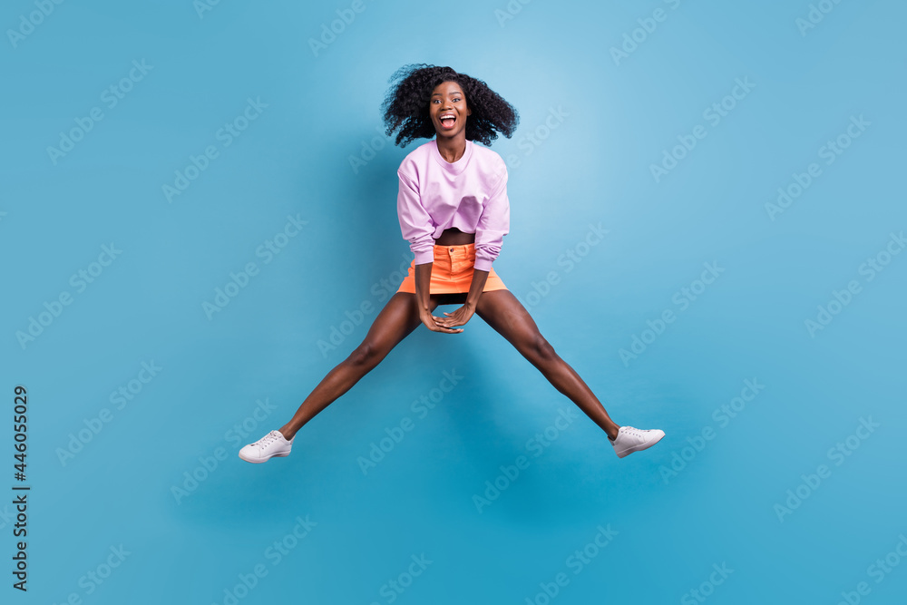 Full length body size view of attractive cheerful comic childish girl jumping having fun fooling isolated over bright blue color background