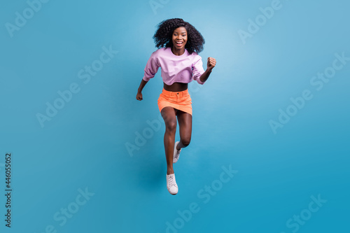 Fototapeta Naklejka Na Ścianę i Meble -  Full length body size view of attractive cheerful energetic motivated girl jumping running isolated over bright blue color background