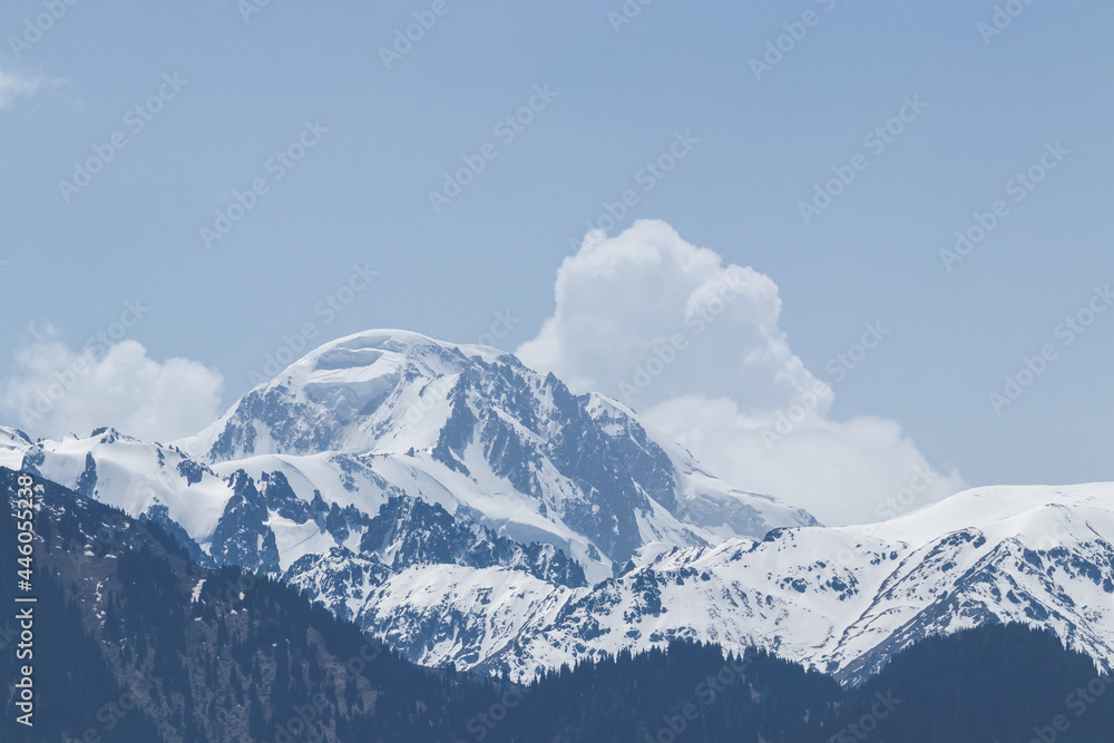 A view of a snowy mountain peak, followed by white clouds