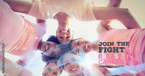 Composition of pink breast cancer ribbon over group of smiling women