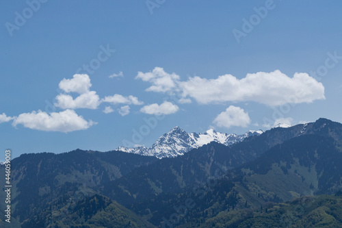 Behind the hills is a snowy mountain peak, and above it are white clouds © Franchesko Mirroni