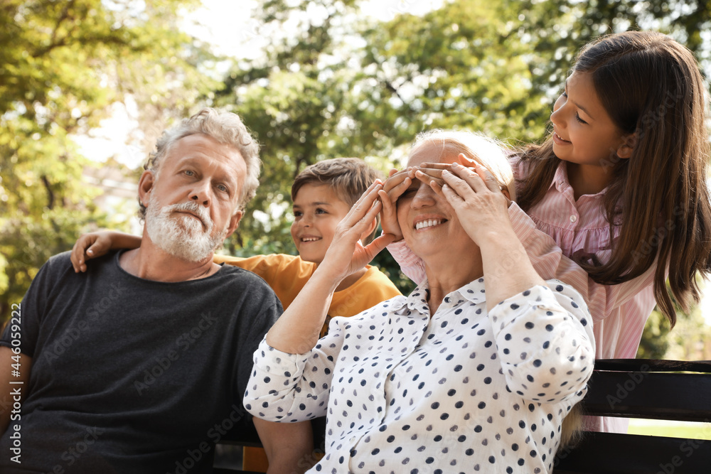 Happy grandparents with little children having fun together in park Happy grandparents with little children having fun together in park