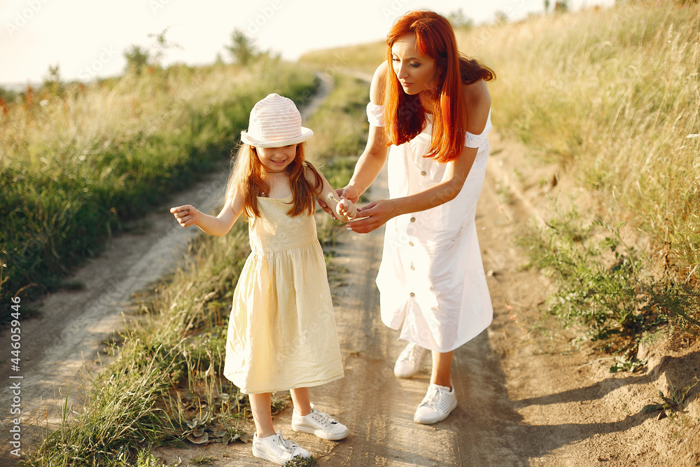 Mother with daughter playing in a summer field