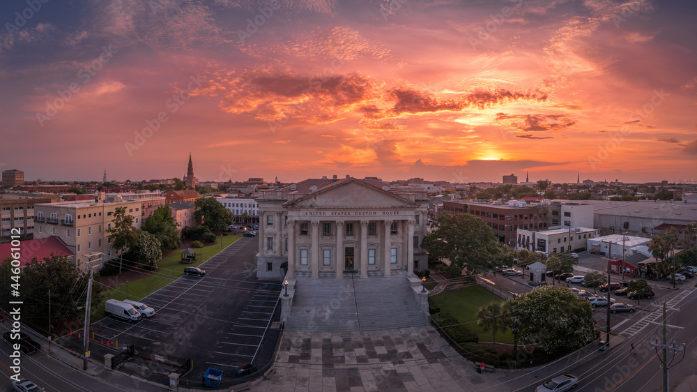 Fototapeta premium Sunset aerial view of old custom house with classical Greek style columns in the historic center of Charleston South Carolina orange, red dramatic sky background