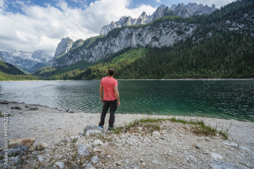 Man enjoying Dachstein Mountains reflected in Gosau lake, Austria