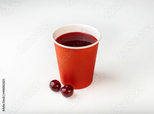 Compote of fresh cherries in paper cups. Drinks to take away. Cherry compote on a white background.