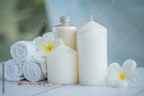 Natural relaxing spa composition on massage table in wellness center    with towels  flowers and salt  candle  on massage table in spa salon. 