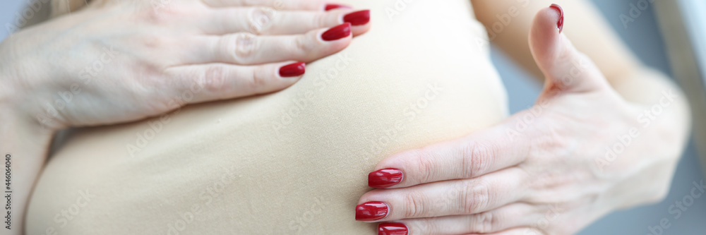 Woman palpating her breasts with hands closeup Woman palpating her breasts with hands closeup