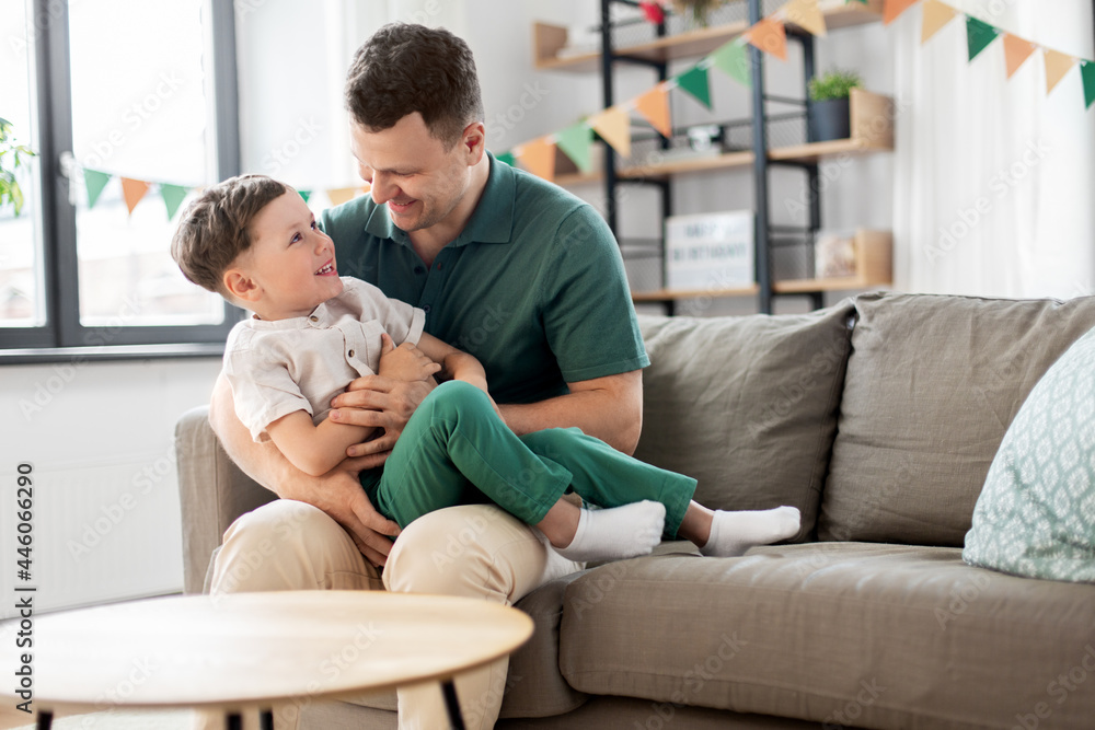 family, fatherhood and people concept - portrait of happy smiling father and little son hugging at home birthday party family, fatherhood and people concept - portrait of happy smiling father and little son hugging at home birthday party
