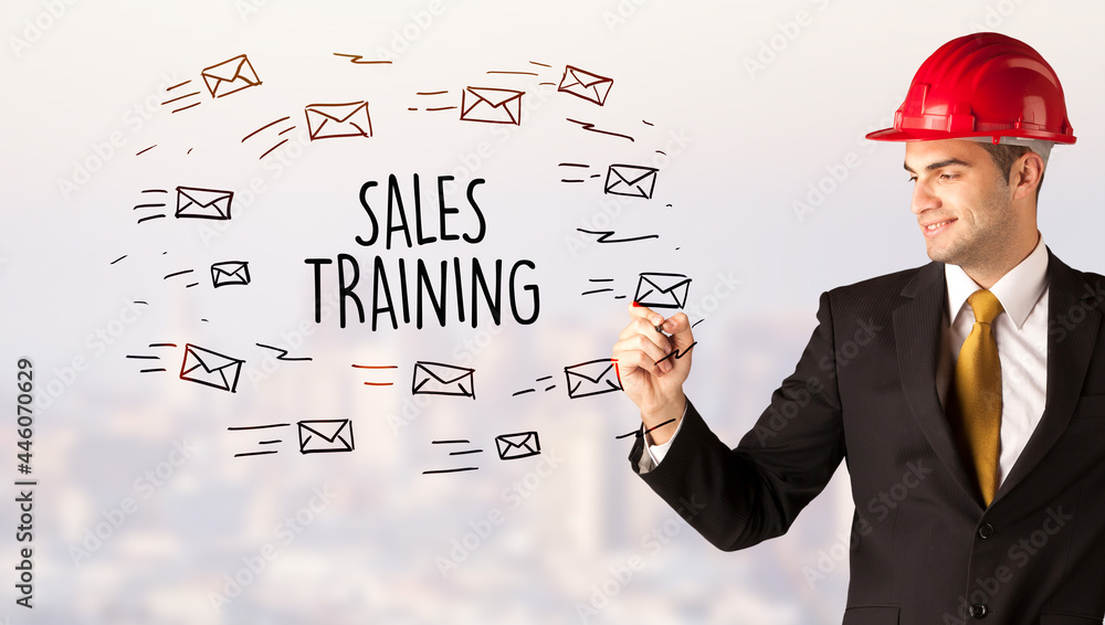 Young businessman with helmet drawing sale sign Young businessman with helmet drawing sale sign