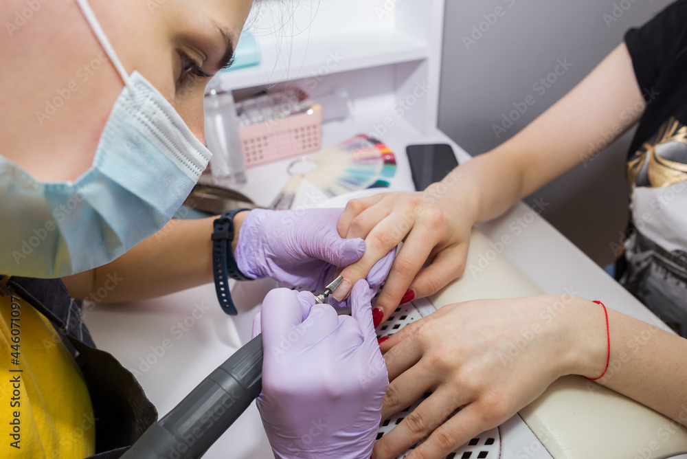 Professional hardware manicure on an electric machine in a beauty salon. Professional hardware manicure on an electric machine in a beauty salon.
