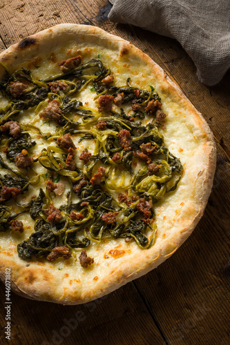 detail of pizza with friarielli and sausage over the wooden board. photo