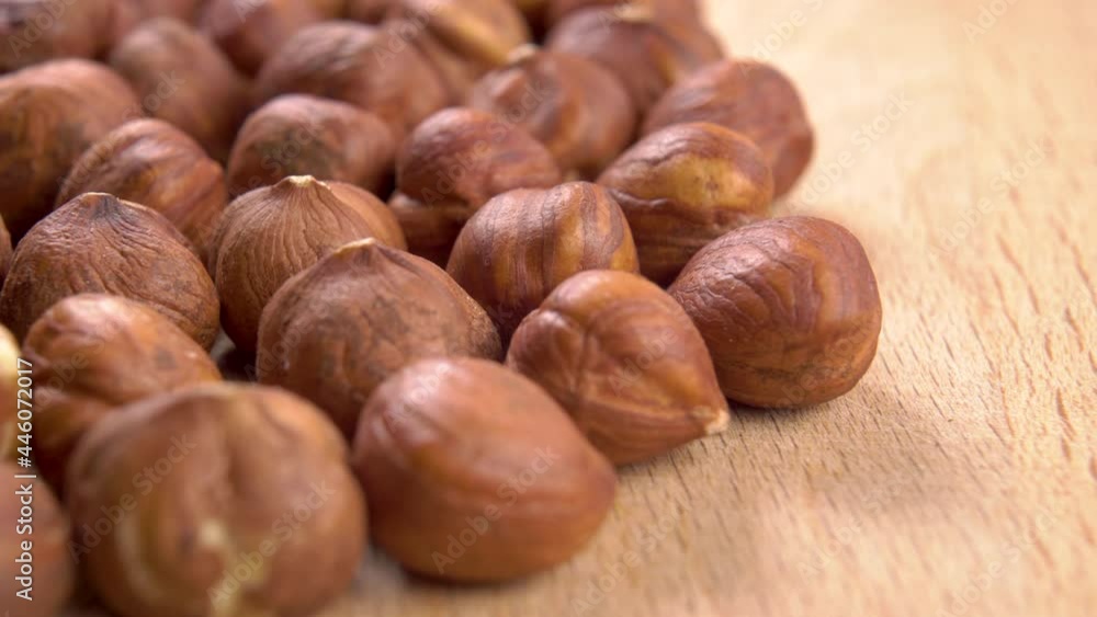 Hazelnut kernels are stacked on a wooden textured board. Macro. Dolly shot. Fresh raw shelled nut ingredient Hazelnut kernels are stacked on a wooden textured board. Macro. Dolly shot. Fresh raw shelled nut ingredient