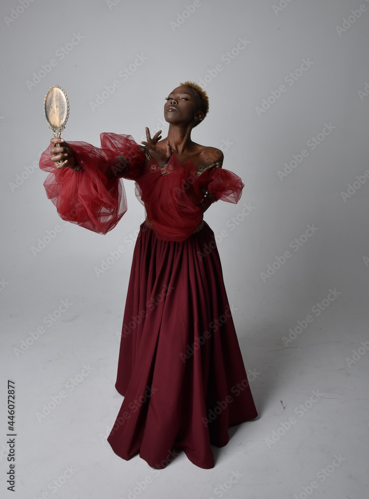 Full length portrait of pretty African woman wearing long red ...