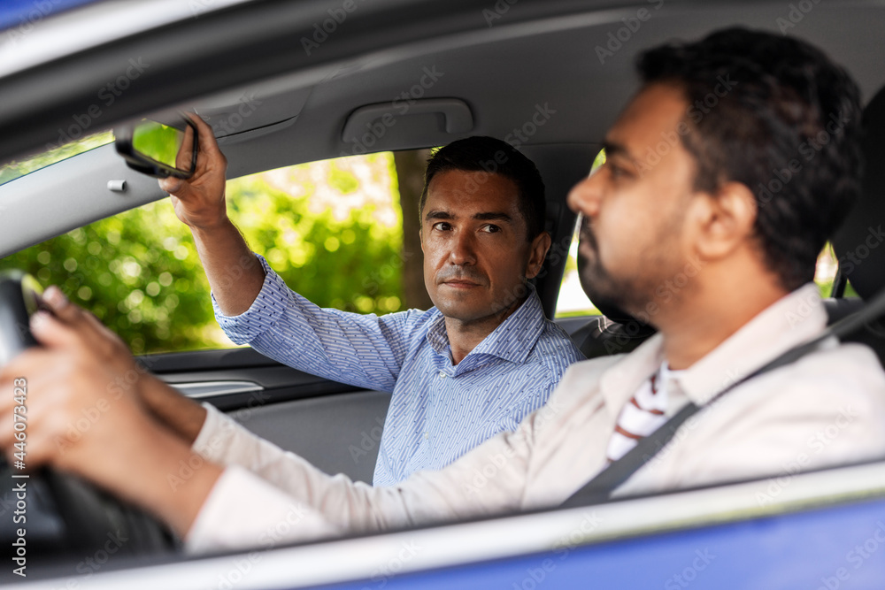 driver courses and people concept - man and driving school instructor adjusting mirror in car driver courses and people concept - man and driving school instructor adjusting mirror in car