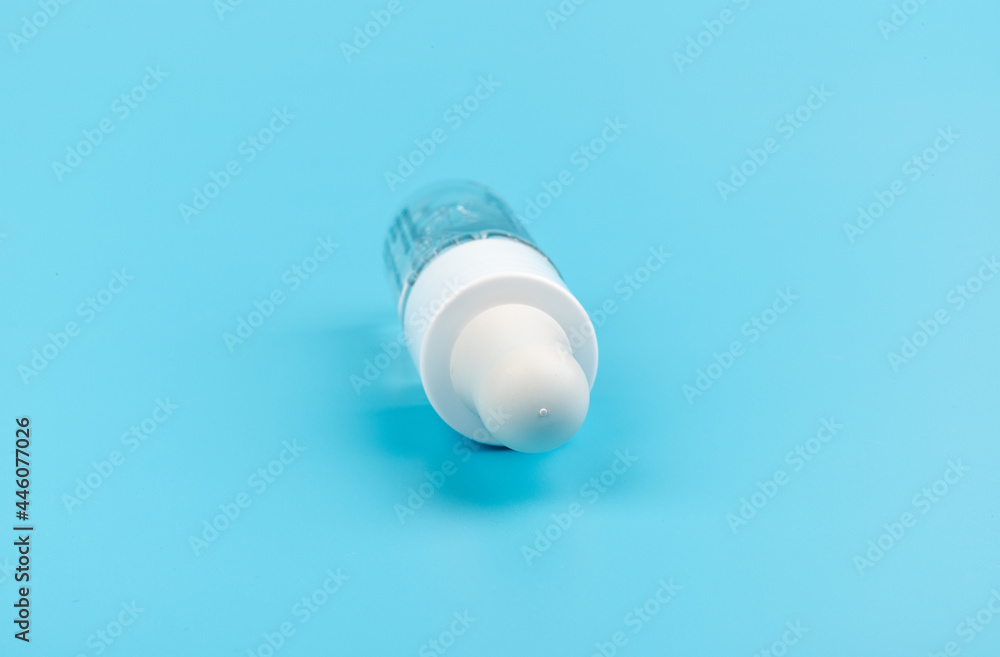 face serum drop with bottle on blue background. face serum drop with bottle on blue background.