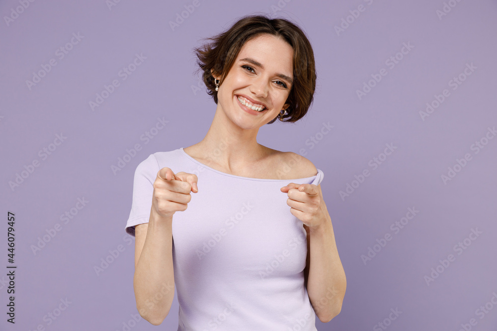 Young cheerful smiling happy stylish woman 20s with bob haircut wearing white t-shirt point index finger camera on you isolated on pastel purple background studio portrait. People lifestyle concept Young cheerful smiling happy stylish woman 20s with bob haircut wearing white t-shirt point index finger camera on you isolated on pastel purple background studio portrait. People lifestyle concept