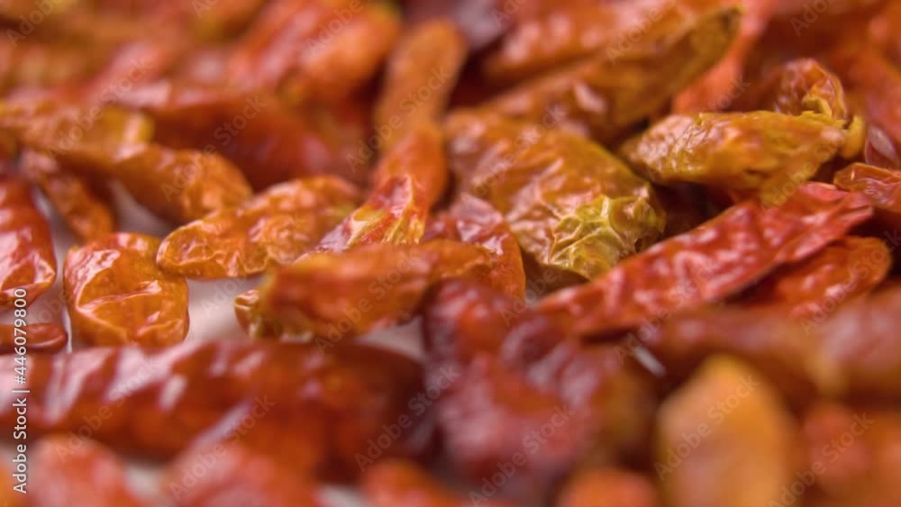 Red dried spicy cayenne piripiri pepper. Falling on a white plate in slow motion. Macro Red dried spicy cayenne piripiri pepper. Falling on a white plate in slow motion. Macro