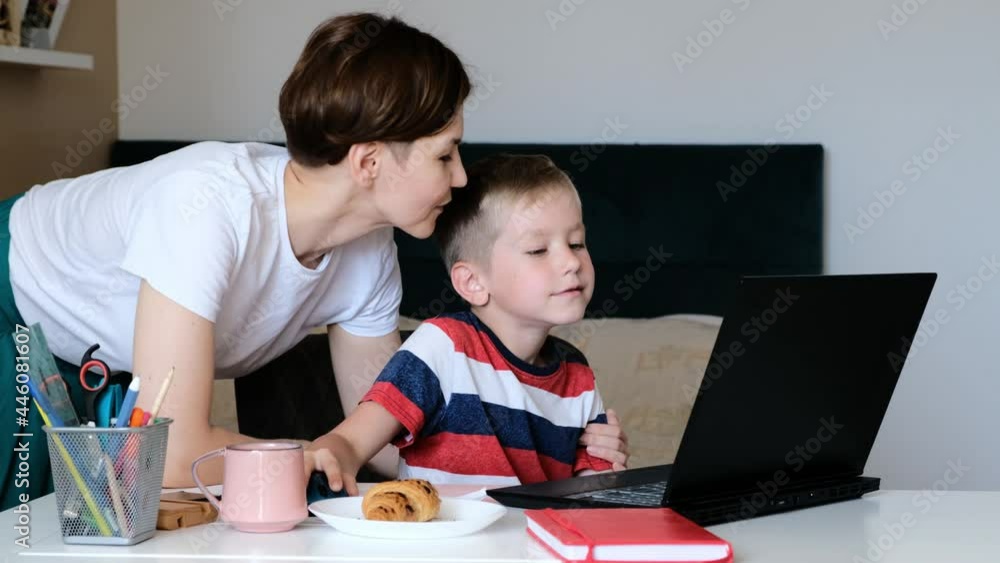 Positive parent mother helping motivating school boyl doing homework at laptop, distant learning. Positive parent mother helping motivating school boyl doing homework at laptop, distant learning.