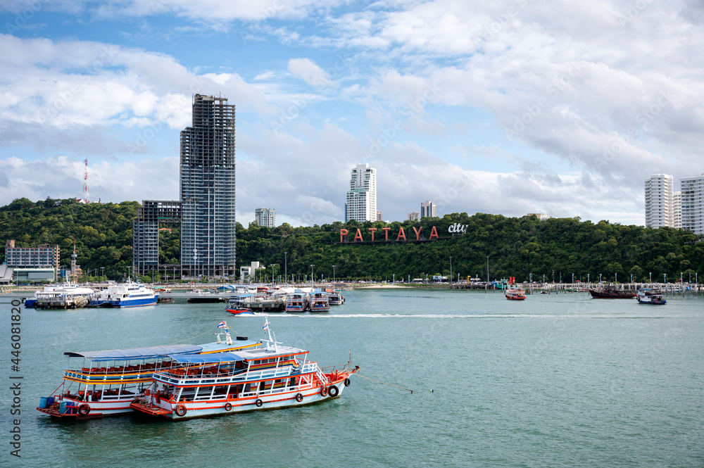 Scenery of Pattaya beach with building and ferry port in tropical sea