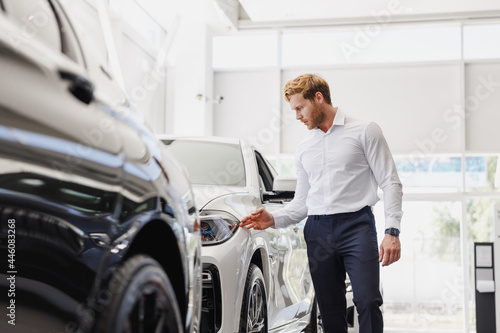 Man adult customer male buyer client wears classic suit white shirt chooses auto wants to buy new automobile touch check car in showroom vehicle salon dealership store motor show indoor Sales concept © ViDi Studio