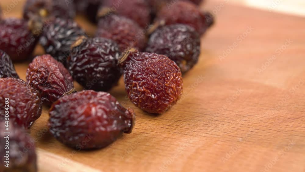 Dried wild rose hips. Macro. Healing natural fruits on a wooden board. Dolly shot. Healthy food concept Dried wild rose hips. Macro. Healing natural fruits on a wooden board. Dolly shot. Healthy food concept