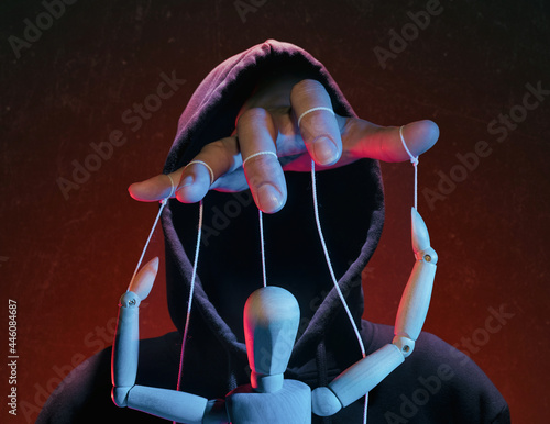 The concept of extortion, blackmail. Man in a hoodie and a puppet. photo