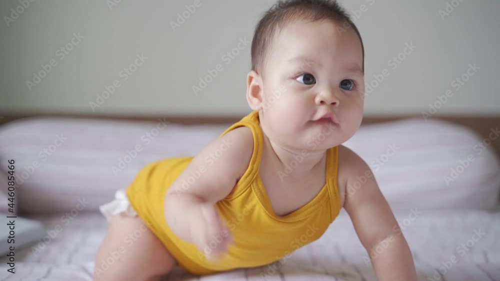 portrait of asian baby infant 6 months old happy smile when playing on bed at home. smiling baby crawling and play. baby face happily close up. authentic life at home. baby sitting and crawling age. portrait of asian baby infant 6 months old happy smile when playing on bed at home. smiling baby crawling and play. baby face happily close up. authentic life at home. baby sitting and crawling age.