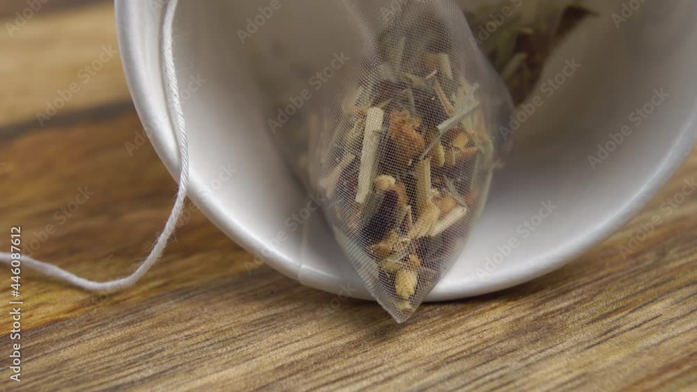 Herbal flower fruit tea in a micro plastic bag in an overturned white cup. Macro. Dolly Shot Herbal flower fruit tea in a micro plastic bag in an overturned white cup. Macro. Dolly Shot