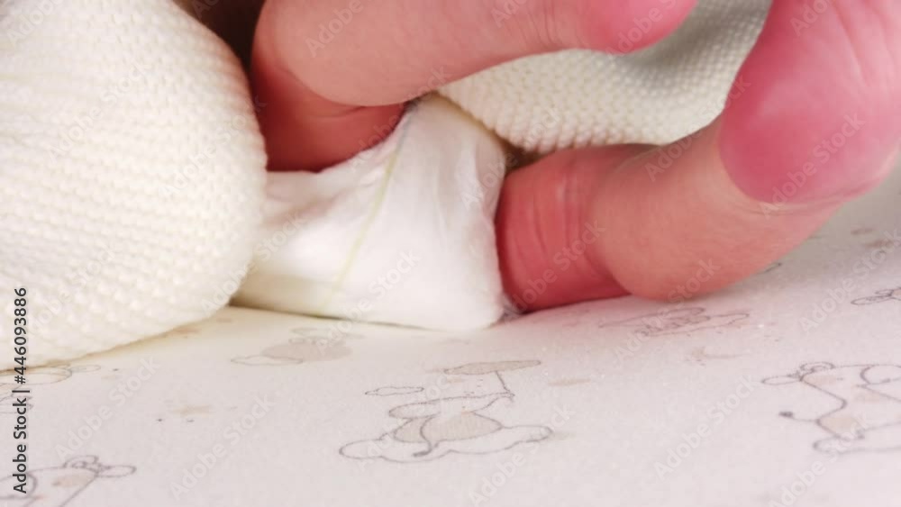 Close up shot of newborn baby in diaper lying on back and jerking her