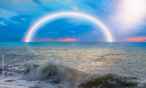 Beautiful landscape with turquoise sea, rainbow over the sea at sunset