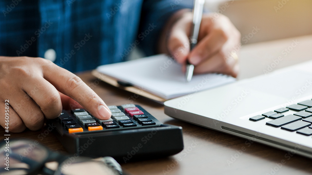 young man holding pen for fill out the document and take note to calculate income and expenses business data, taxes, payment, counting finance.accounting, statistics, and analytic research concept young man holding pen for fill out the document and take note to calculate income and expenses business data, taxes, payment, counting finance.accounting, statistics, and analytic research concept