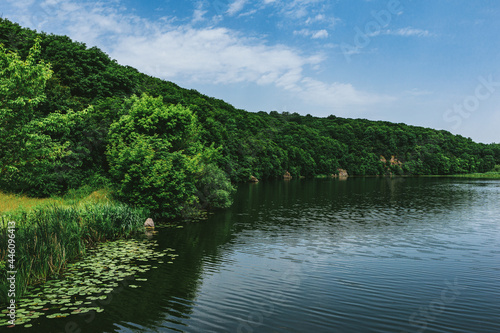 Beautiful summer landscape with river and green forest.