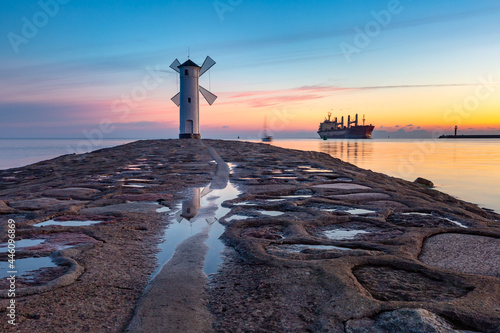 Baltic sea and Stawa Mlyny, navigation beacon in shape of windmill at sunset, official symbol of Swinoujscie, Poland