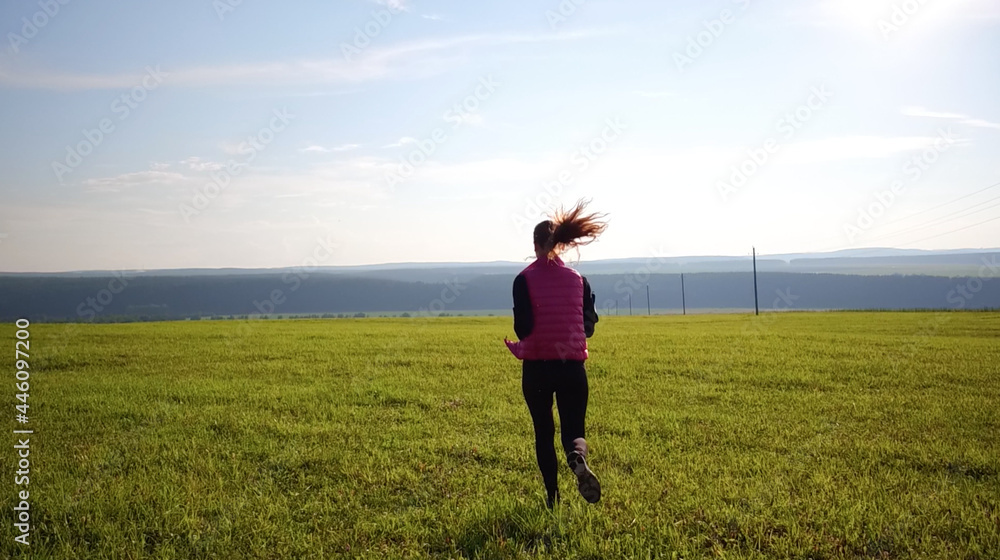 Pretty girl wearing sportswear and running in green forest at mountain during spring Pretty girl wearing sportswear and running in green forest at mountain during spring