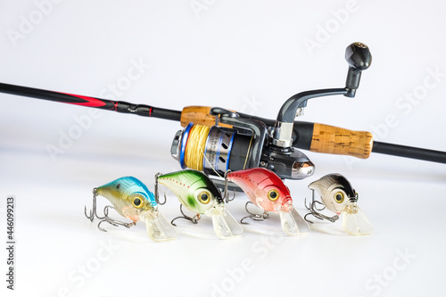 A fishing spinners and wobblers with fishing rod on background. Standard type of fishing lure.