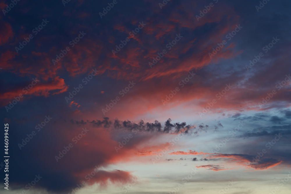 Beautiful evening blue sky at sunset with flaming bright light clouds. A warm summer evening at sunset. Bright sunset. Beautiful evening blue sky at sunset with flaming bright light clouds. A warm summer evening at sunset. Bright sunset.