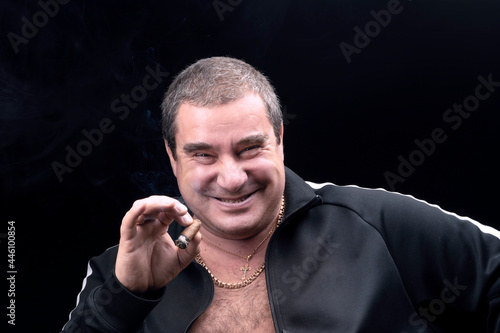 a kind, genuinely laughing white fat man, smoking a cigar. sincere emotions. A good-natured adult man, a portrait on a black background